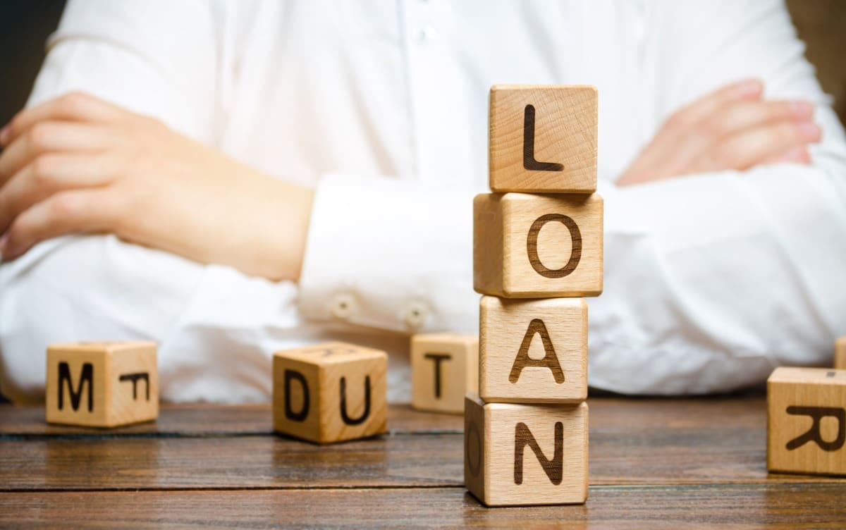 Person with loan blocks on table.