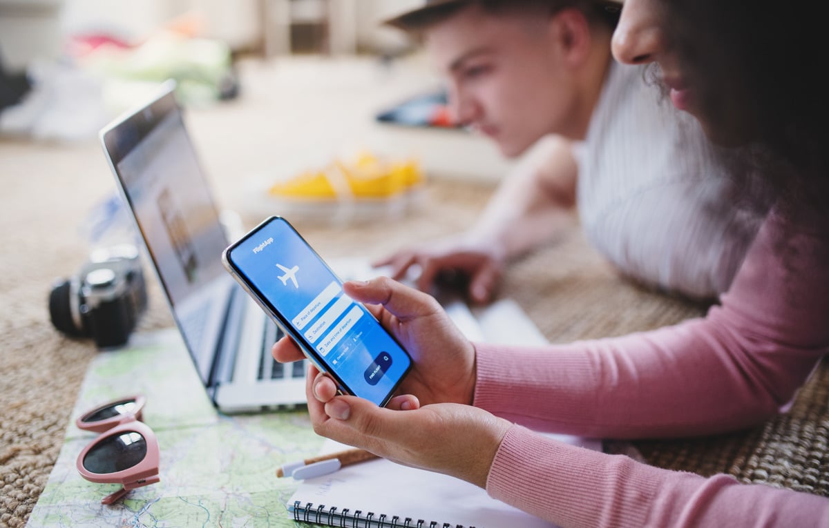 Person booking flight on smartphone at home.
