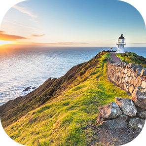 Scenic view of lighthouse on coastal cliff at sunset